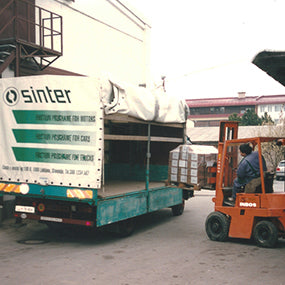 A forklift loads boxed goods onto a Sinter lorry