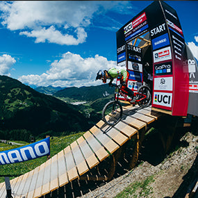 A mountain biker drops out of the start ramp at a UCI downhill race